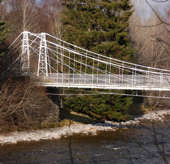 Weiße Hängebrücke aus Eisen, die den River Dee in Schottland überspannt.