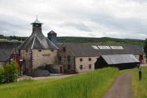 Die mit Schiefer gedeckten Steingebäude der Balvenie Destillerie liegen in einem grünen Tal des River Fiddich.