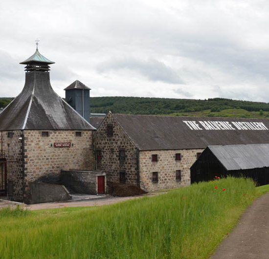 Die mit Schiefer gedeckten Steingebäude der Balvenie Destillerie liegen in einem grünen Tal des River Fiddich.