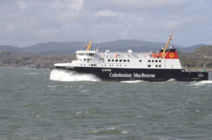 Schnell fahrende schwarz-weiße Fähre mit dem rot-gelben Logo und Schriftzug von Caledonian MacBrayne.