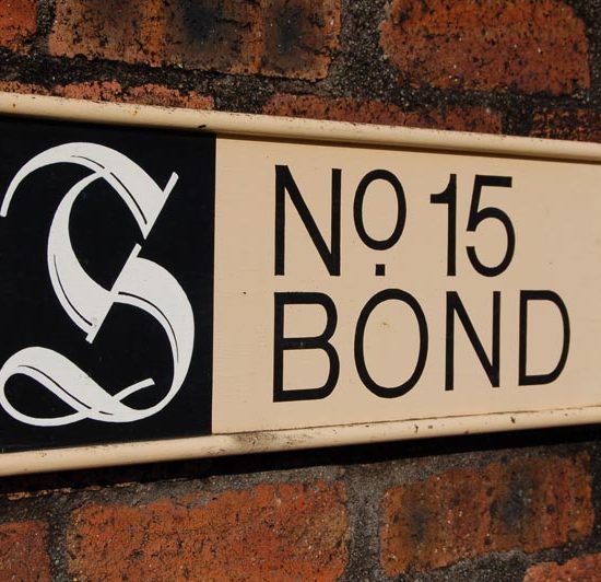 Hinweisschild No 15 Bond von Springbank vor einer Backsteinwand.