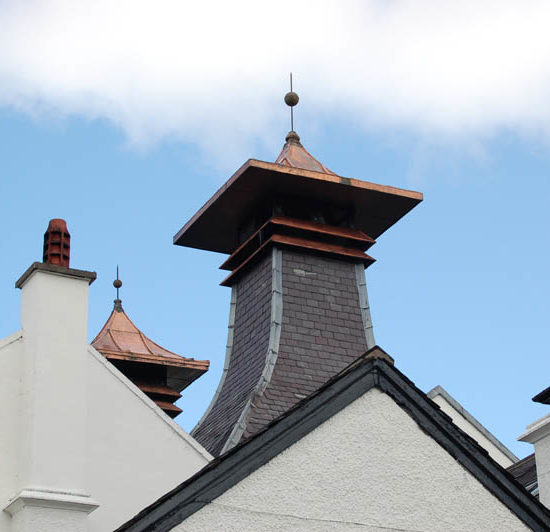 Zoombild der schieferverkleideten, kupfergedeckten Pagode einer Whiskydestillerie.