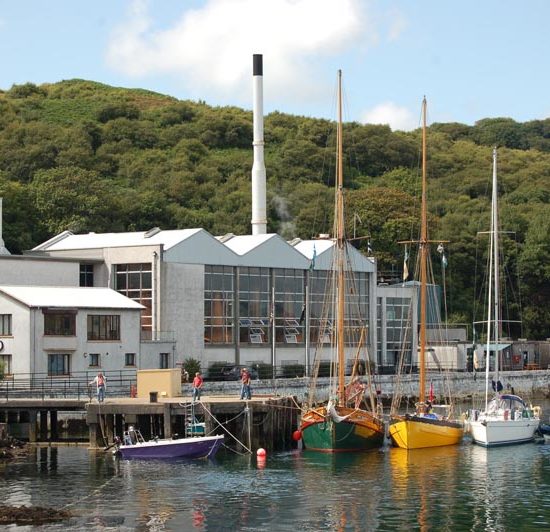 Bunte Segelboote liegen am Pier der Caol Ila Distillery.