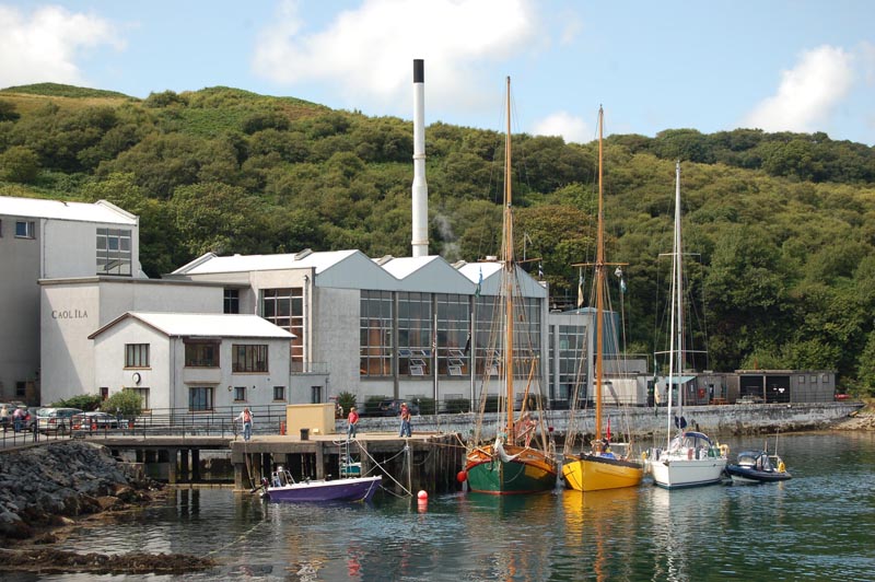 Bunte Segelboote liegen am Pier der Caol Ila Distillery.