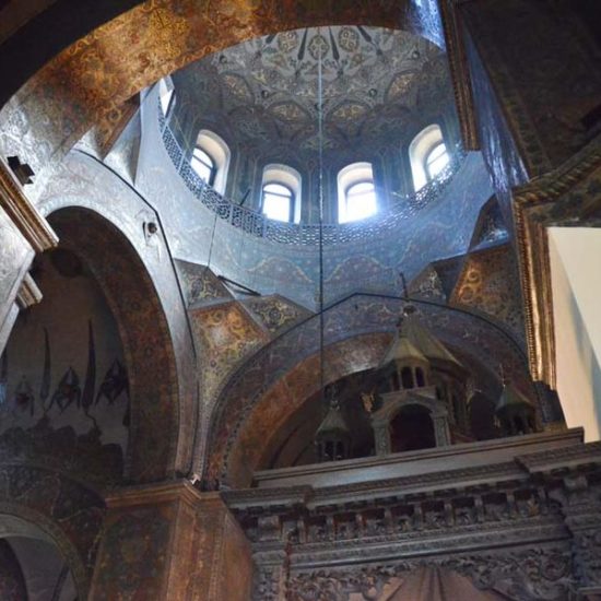 In den mit farbigen Wandmalereien gestalteten Chorbereich der Kathedrale Etschmiatsin fällt Licht durch die Fenster der hohen Kuppel.