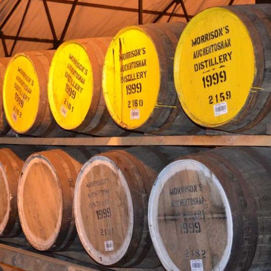 Zwei Reihen mit Whiskyfässern der Auchentoshan Distillery.