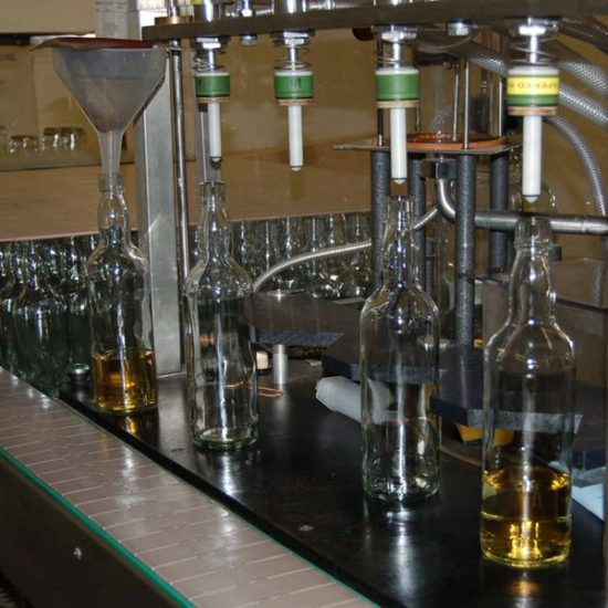 Kleine Abfüllanlage auf de vier Flaschen mit Whisky befüllt werden.