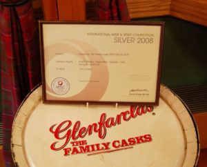 Ein Fass von Glenfarclas The Family Cask mit einer Auszeichnung der IWSC Competition in einem Holzrahmen.