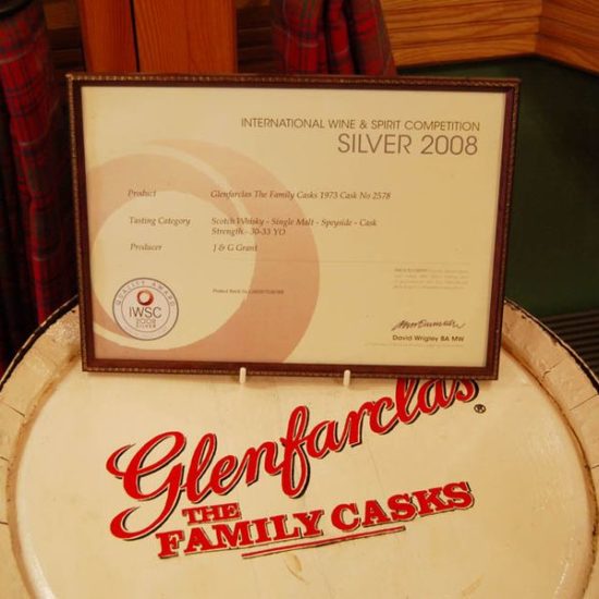 Ein Fass von Glenfarclas The Family Cask mit einer Auszeichnung der IWSC Competition in einem Holzrahmen.