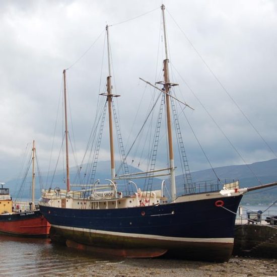 Zwei Schiffe bei Niedrigwasser am Pier von Inveraray im schottischen Loch Fyne.