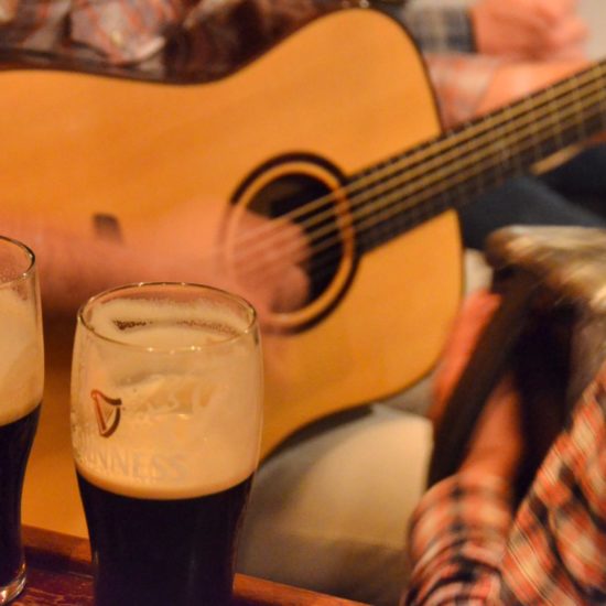 Zwei angetrunkene Gläser Guinness von zwei Musikern mit karierten Hemden.