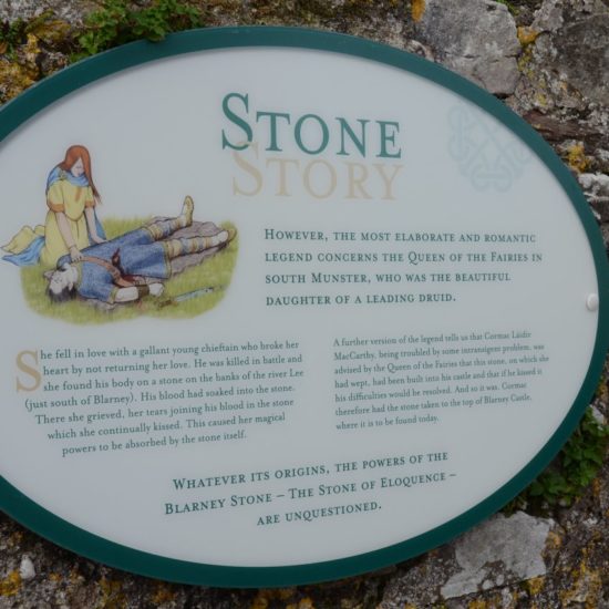 Rundes Schild vor Steinmauer, das die Geschichte des Stone of Blarney erklärt.