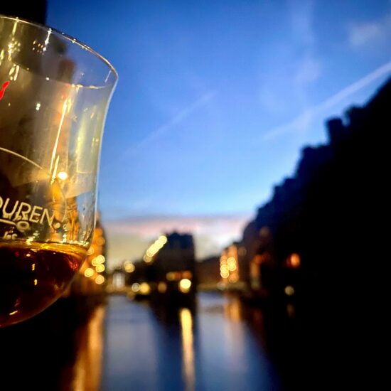 Whiskyglas von REISEKULTOUREN im Abendlicht der Speicherstadt Hamburg.