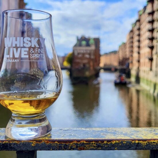 Glas der Whisky Live Hamburg auf einer Brücke der Speicherstadt.